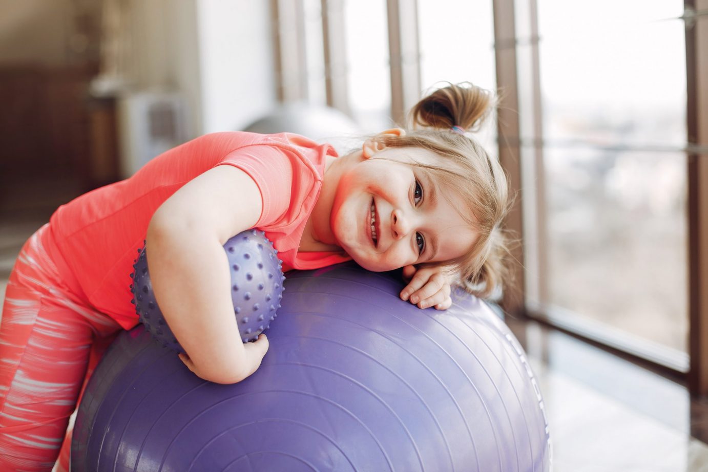 Beautiful girl in the gym. Cute little child in a pink sportswear